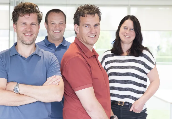 Roel, Jeroen, Erwin en Barbara staan samen op kantoor